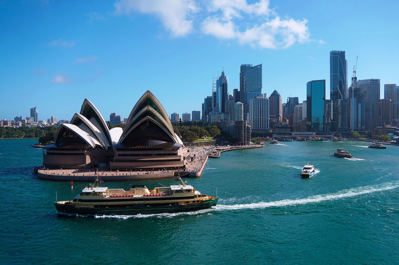 Sydney Opera House and harbour with ferries and the city skyline behind