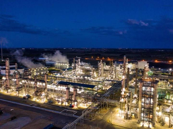 An illuminated oil refinery seen from above at night