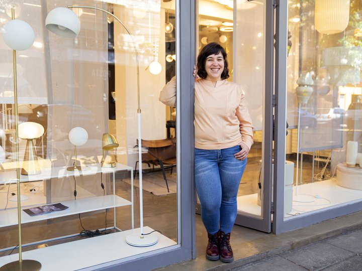 A retail worker at the entrance of a modern lighting store
